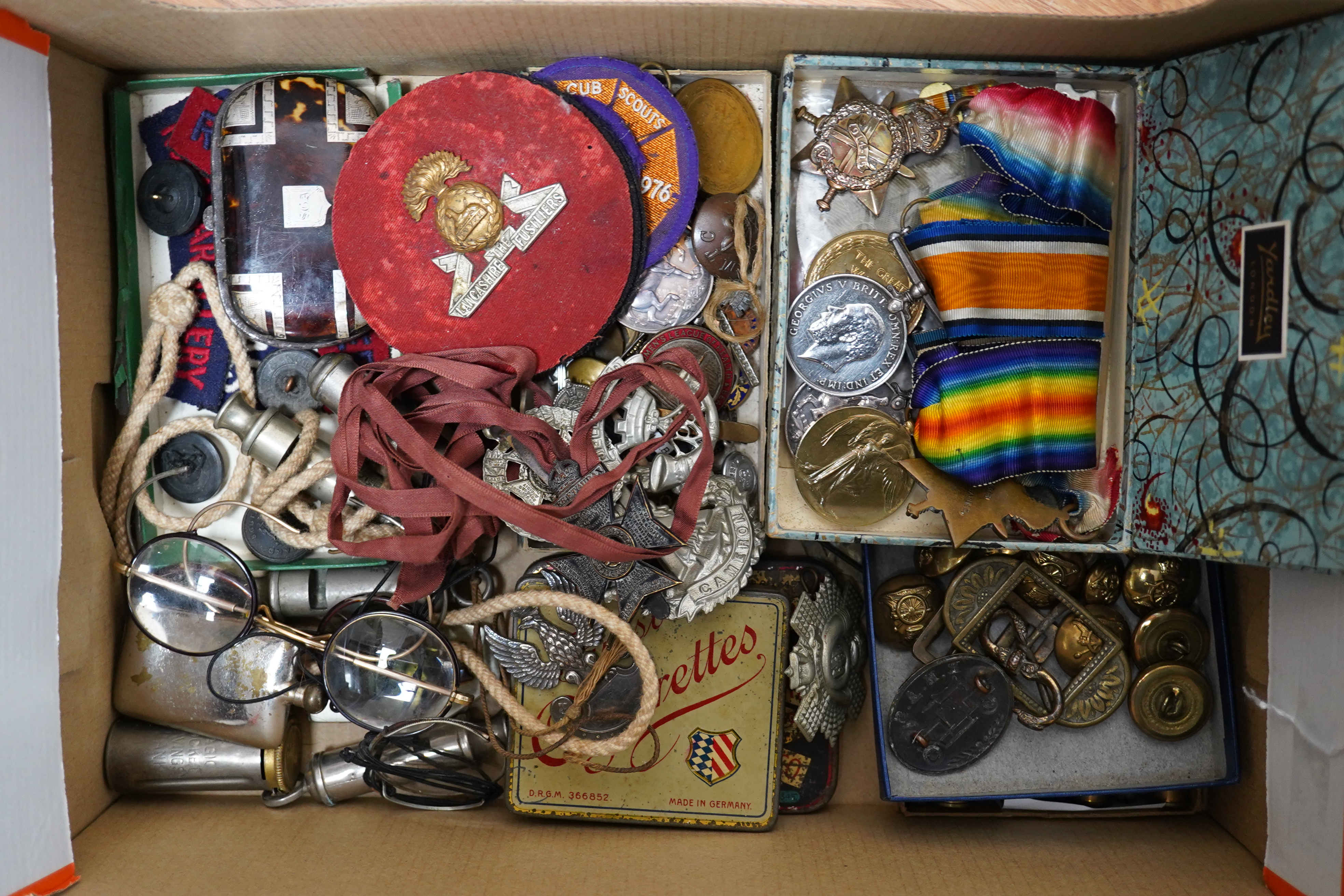 A collection of military medals, cap badges and buttons etc. including; a First World War Royal Navy Air Service cap badge, two WWI medal trios awarded to PTE. V.J.P. Barnes RIF. BRIG., and L.Cpl. W. Howard. NOTTS & DERB